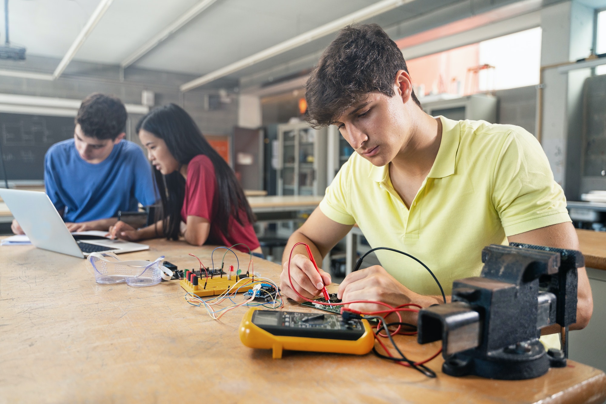 College Student working on electronics circuit in the science technology workshop